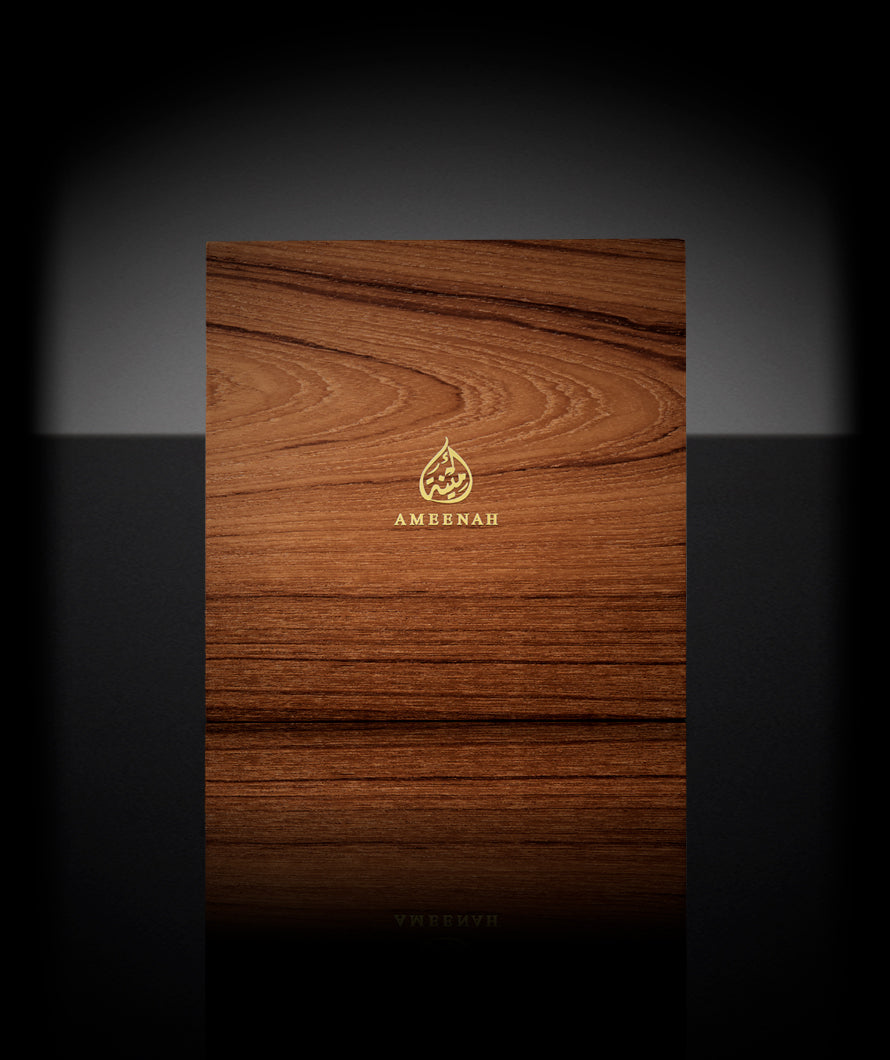 Close-up of the Prestige Gift Set wooden box with two Ameenah perfume bottles placed inside a black velvet interior.