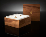 Close-up of the Prestige Gift Set wooden box with two Ameenah perfume bottles placed inside a black velvet interior.