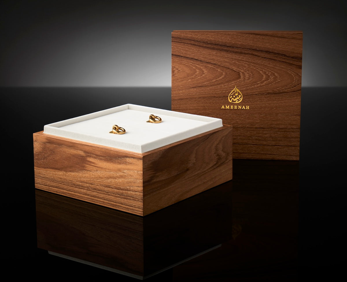 Close-up of the Prestige Gift Set wooden box with two Ameenah perfume bottles placed inside a black velvet interior.