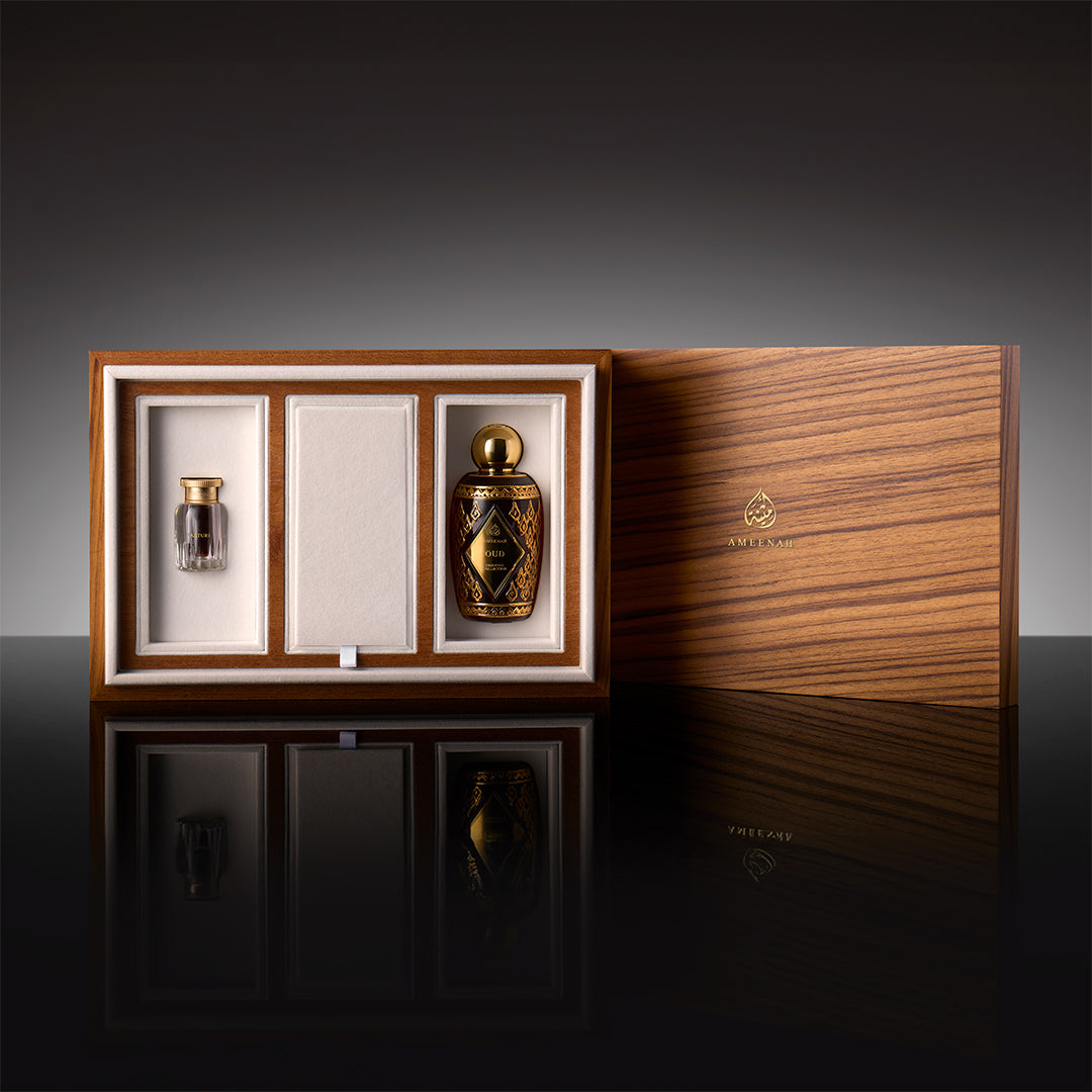 A three-slot Prestige Gift Set wooden box containing Ameenah perfumes and oud oils displayed on a dark velvet base.