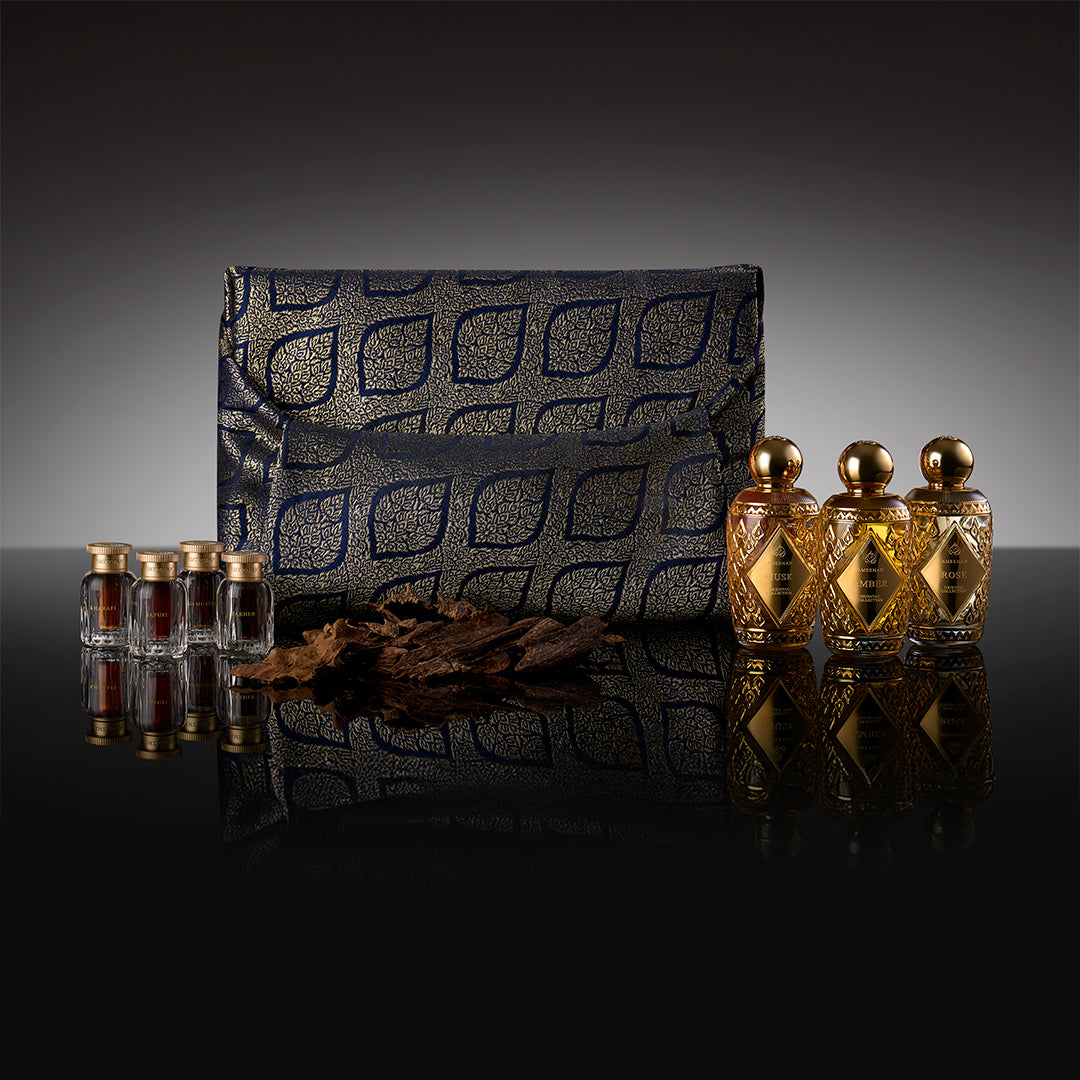 A three-slot Prestige Gift Set wooden box containing Ameenah perfumes and oud oils displayed on a dark velvet base.