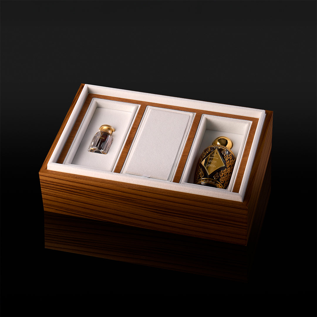 A three-slot Prestige Gift Set wooden box containing Ameenah perfumes and oud oils displayed on a dark velvet base.